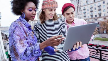 Using laptop. Three smart stylish freelancers using their laptop before starting the project