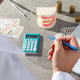 Man with pen in hand notepad cash calculator jaw and dental instruments on gray background