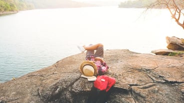 Man sitting on rock by lake