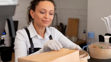 Woman preparing food for home delivery.
