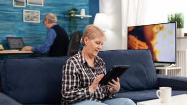 Happy mature woman relaxing on couch enjoying retirement lifestyle