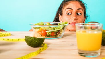 Woman prepares a healthy meal with salad and orange juice