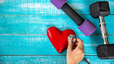 Just above the image of the hand holding a heart on a table