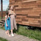 Young pregnant mother talking with her little daughter while they walking outdoors