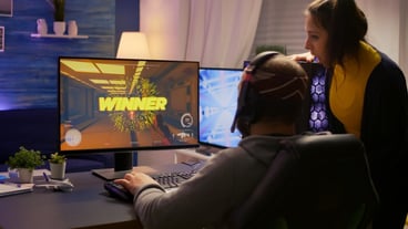 Back shot of excited couple, esport gamer winning virtual tournament video game using RGB equipment. Winner man playing online first person shooter competition with powerful professional computer
