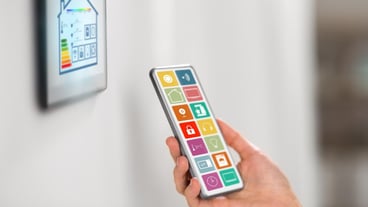Hand with smart home icons on smartphone screen