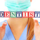 doctor's hands showing a dentist text on wooden blocks over white background
