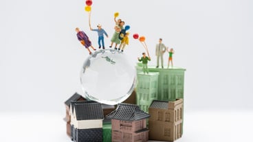 Miniature people, family and children with colorful balloons on the house.