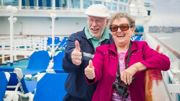 Senior Couple With Thumbs Up on Deck of Cruise Ship