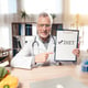 Smile doctor is holding diet sign in clinic room.