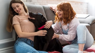 Medium shot women playing with dog