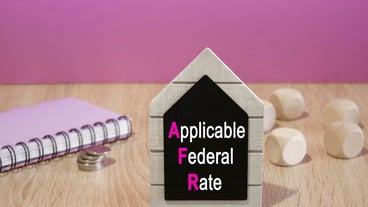 Black table with the words Applicable Federal Type Beautiful purple background silver coins on the table.