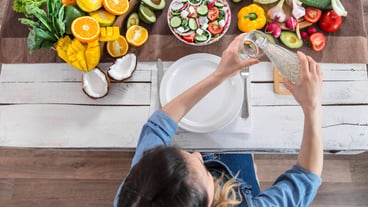 A young woman at the dinner table pours water