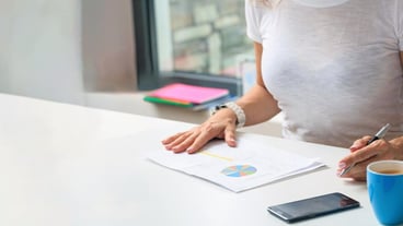 Woman working in the office statistics data sheets on desk