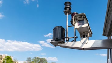 CCTV Security camera over blue sky background.
