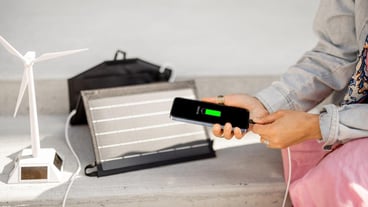 Woman charge phone from a portable solar panel