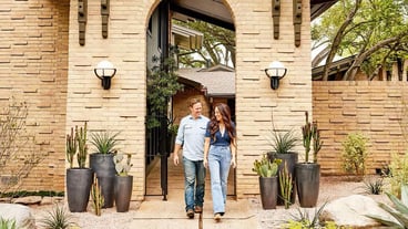 a couple walk into a house with a door that says quot welcome to you quot