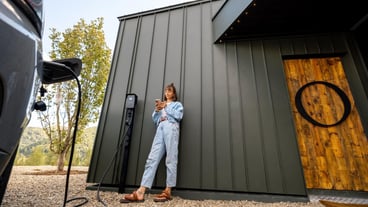 Woman waits for electric car to be charged