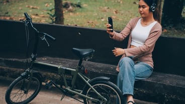 Happy young Asian woman while riding a bicycle in a city park She smiled using the bicycle of transportation Environmentally friendly concept
