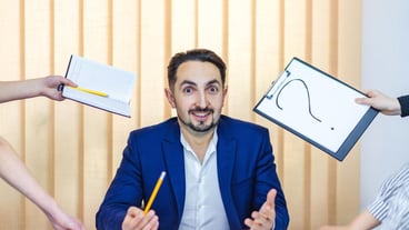 Photo of a businessman in blue suit having a lot of work sitting in the office