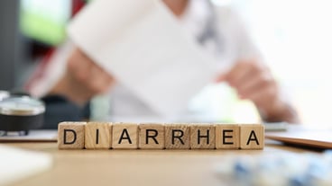 Diarrhea letters collected from cubes and blurred doctor with roll of toilet paper in background