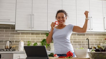 Beautiful woman is cooking delicious dishes at her home kitchen