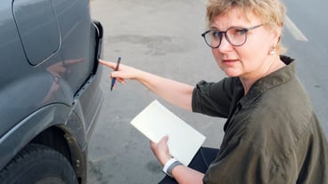 Middle-aged insurance agent performs a pre-insurance inspection of the car