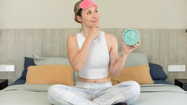 smiling with a happy confident expression with hand on chin alarm clock concept