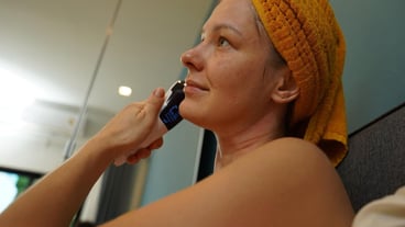 Young woman using infrared massager