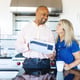 A couple in a modern kitchen smiling and enjoying coffee The man holds a tablet Bright kitchen happy couple coffee time modern kitchen setting Couple are happy in modern kitchen