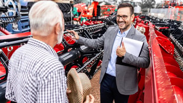 Tractor salesman presenting agricultural equipment and selling combine harvester to the customer