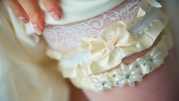 Satin wedding garter on the bride foot