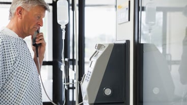 Patient with I.V drip on payphone