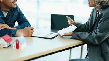 Guarantee Insurance Sign a contract couple a smiling couple is signing a contract to invest in real estate with the Mortgage officer with the bank