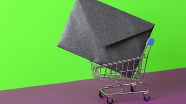 Shopping cart with envelope on green-violet background