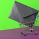 Shopping cart with envelope on green-violet background