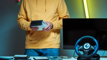 Cropped view of a man standing and holding compact discs with video games
