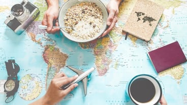 Cropped image of people holding breakfast bowl and toy airplane on map