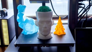 Art models printed on d printer on desktop of d printer models of prototype human head with brain