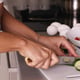 Human hands cooking vegetables salad in kitchen.