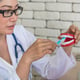 Mature doctor brushing dentures in the clinic