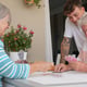 Happy multi generation family enjoying free time together sitting outdoors smiling playing cards