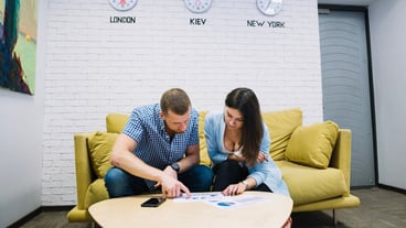 Colleagues looking at charts on sofa