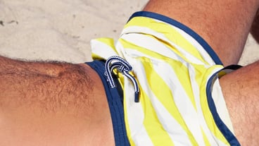 Midsection of man lying on sand at beach