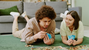 Couple relaxing on floor and playing board game