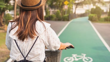 Young woman riding bicycle on bike lane in the park