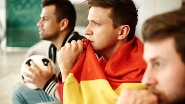 Side view of football fans praying at home