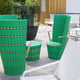 Restaurant with green wicker chair tables and different colours of chairs