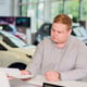 Successful businessman in car dealership - sale of vehicles to customers