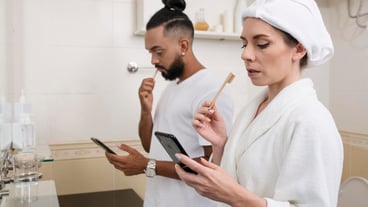 Man and woman checking their phones even in their bathroom
